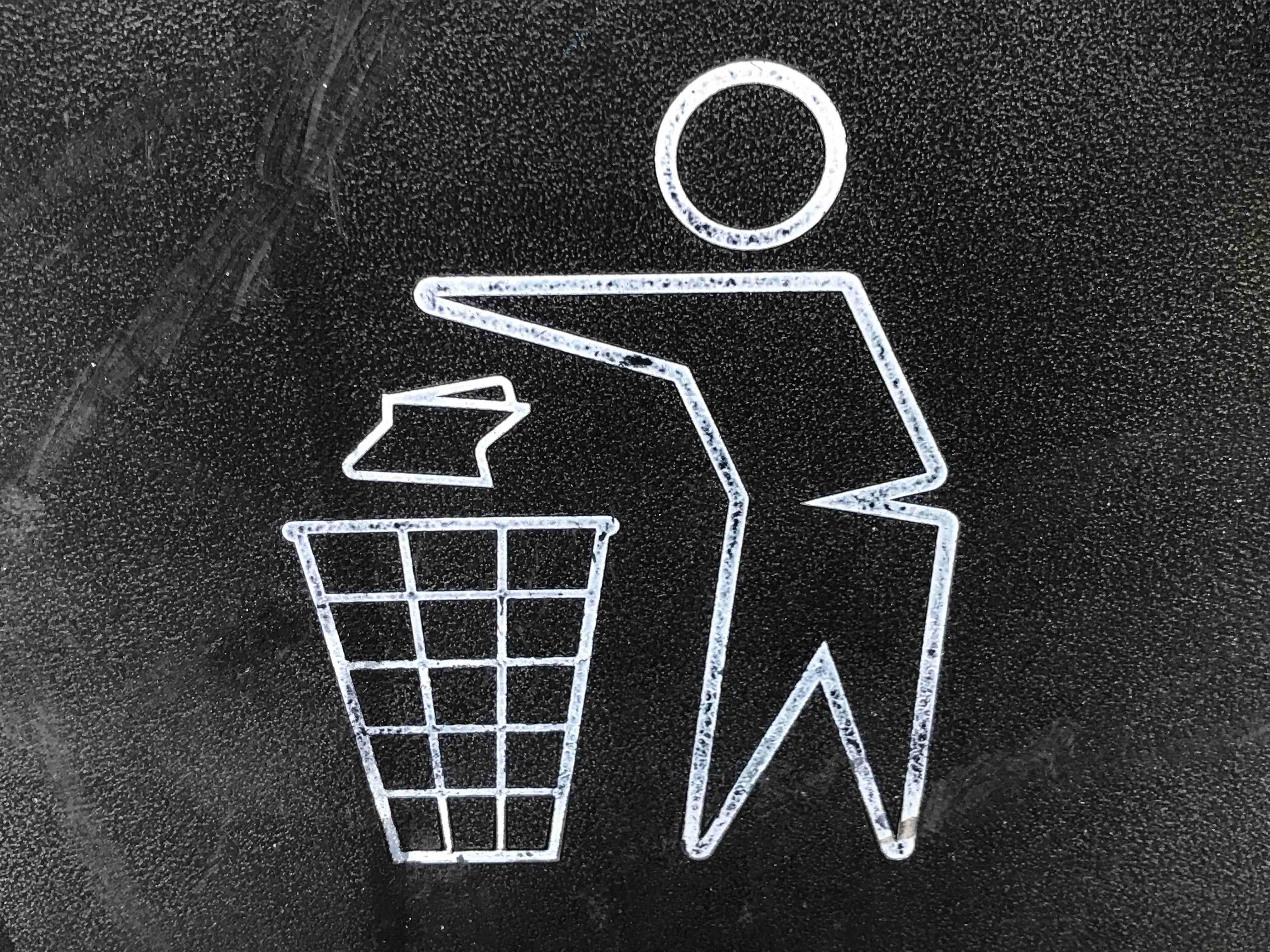 Chalk drawing of person disposing waste into trash bin