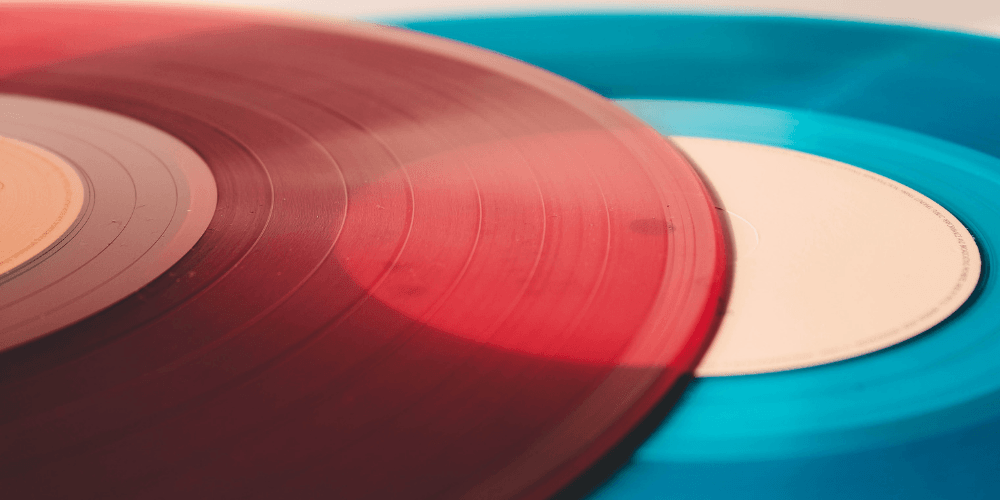 a close up photo of a red vinyl record sitting on top of a blue vinyl record