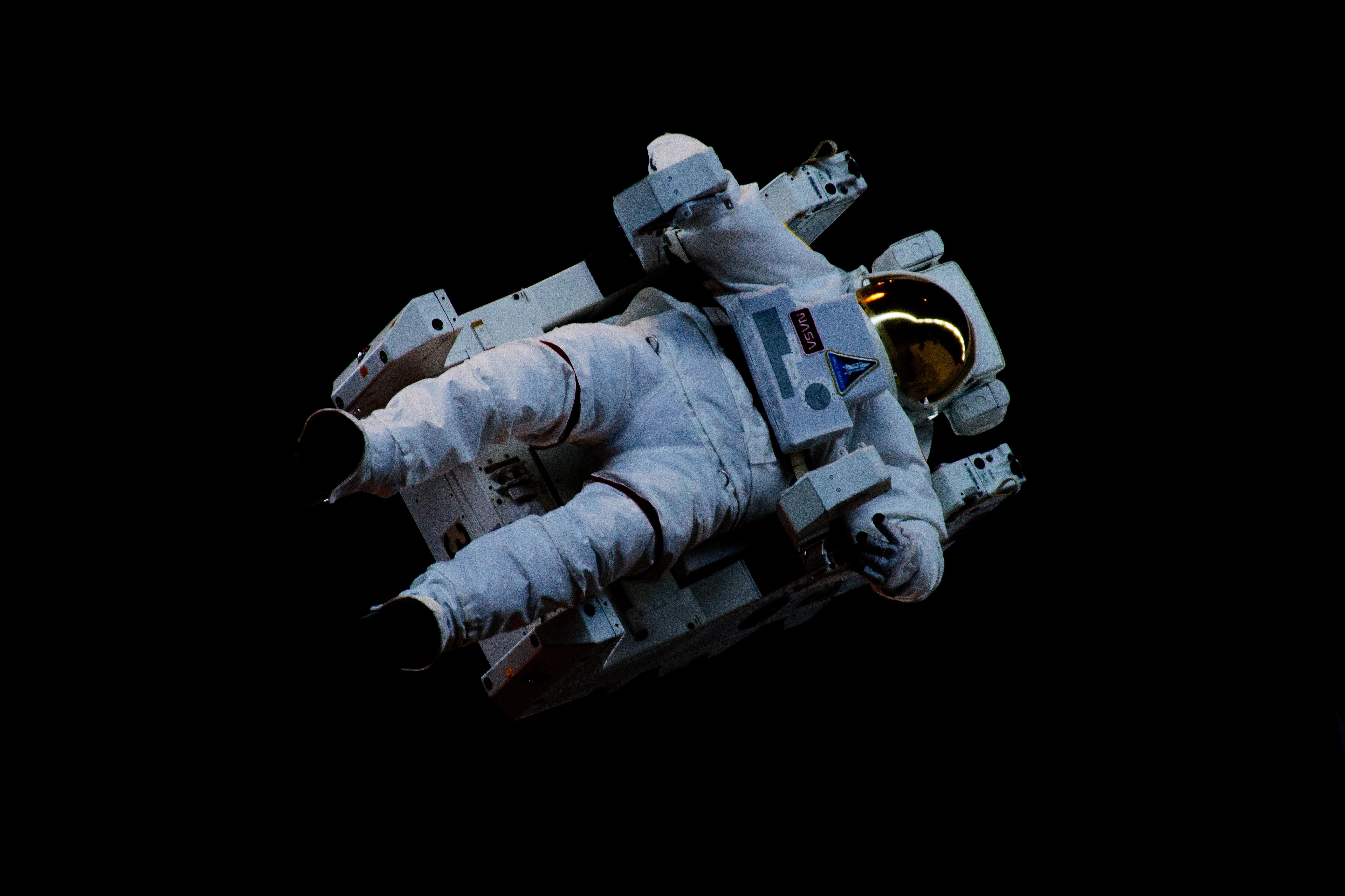 an astronaut in spacesuit floats suspended in space