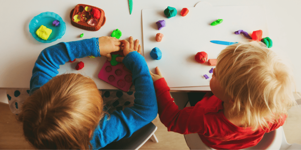 two children playing with colored dough
